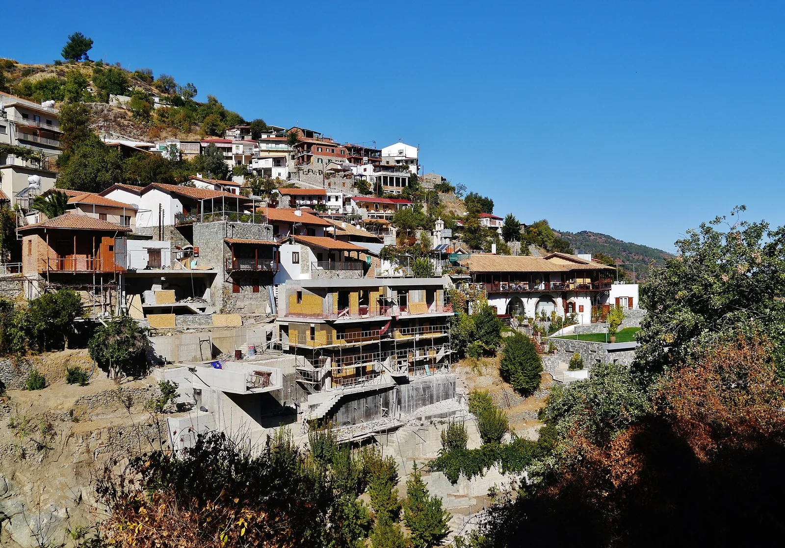 Traditional houses with wooden balconies on the hillside of Kalopanagiotis, Troodos