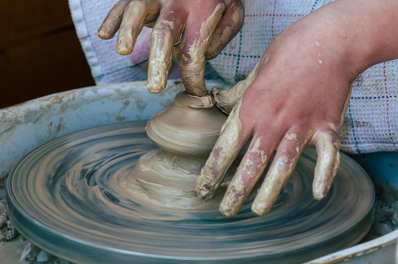 Child shaping clay at a pottery class