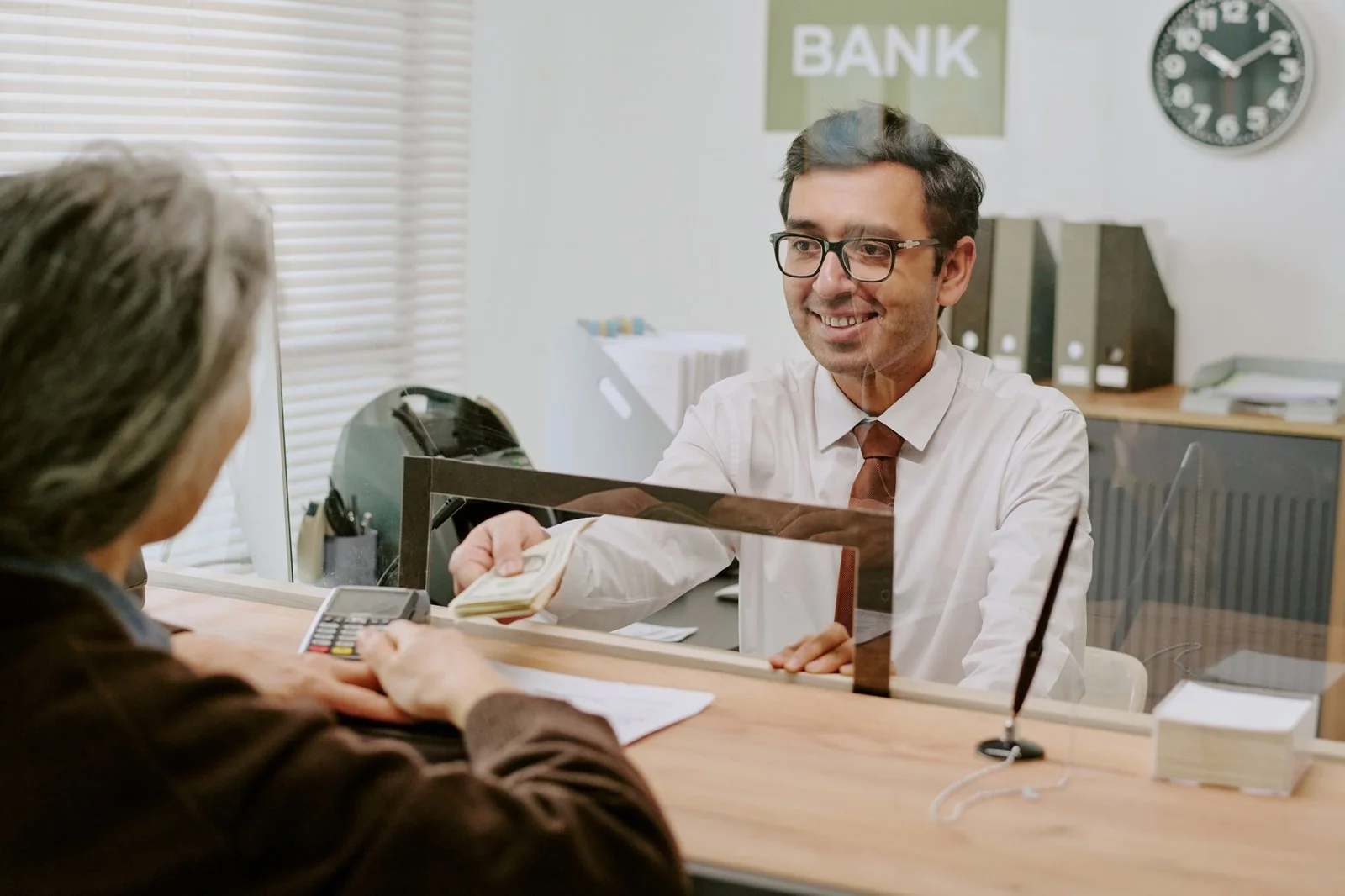 Bank teller smiling while helping a customer