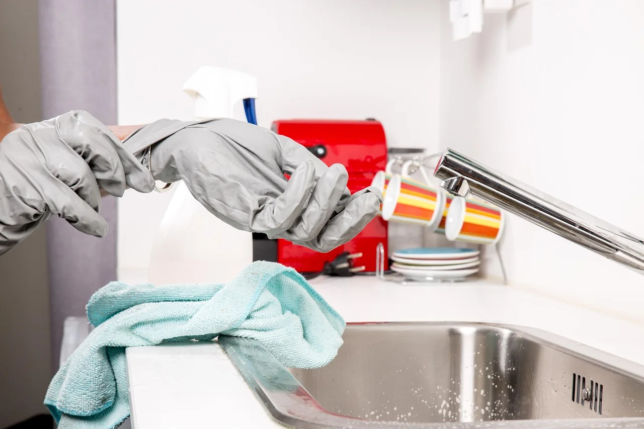 Putting on rubber gloves to clean the kitchen