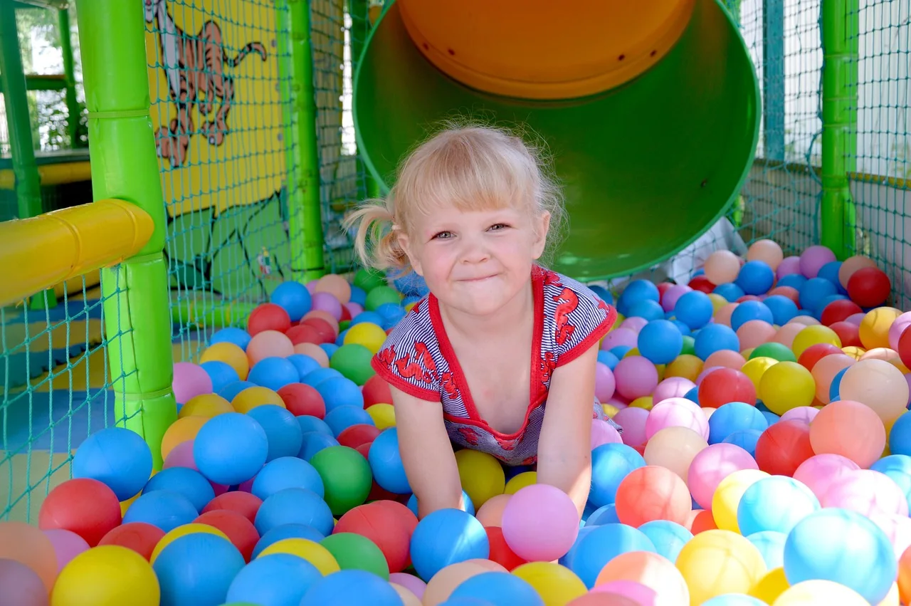 Child playing in a ball pit at an indoor playground