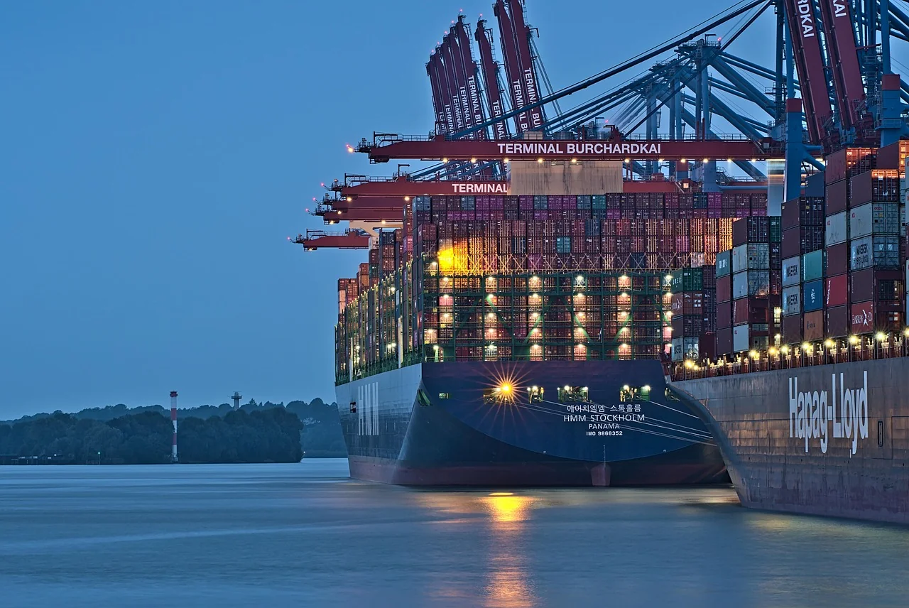 Stacked shipping containers and gantry cranes at a container port, the way most household moves reach Cyprus
