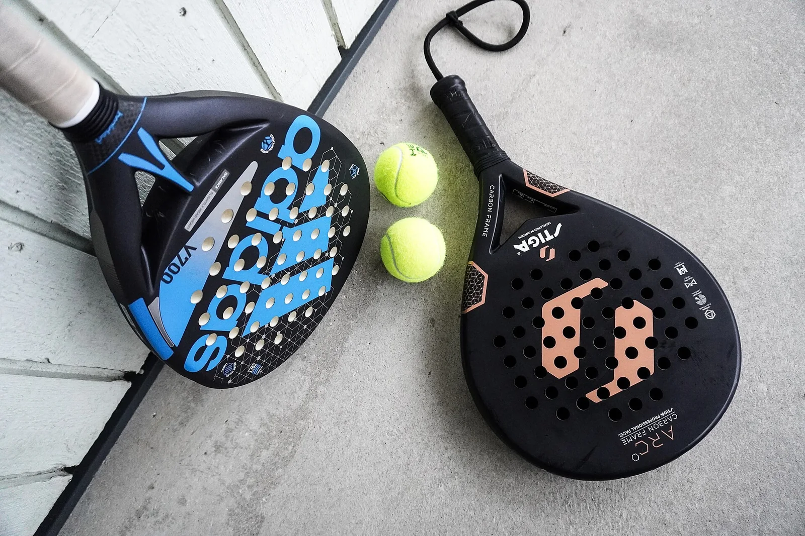 Two padel rackets and balls on a court