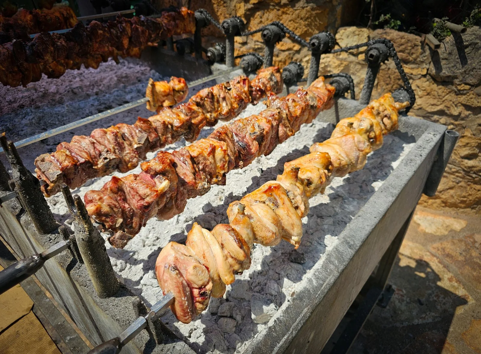 Pork, lamb and chicken cooking on a charcoal grill, traditional Cypriot souvla