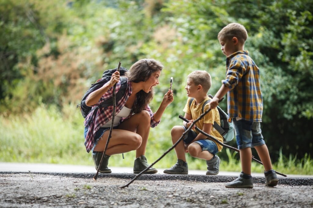 Mother and her young sons hiking through a forest