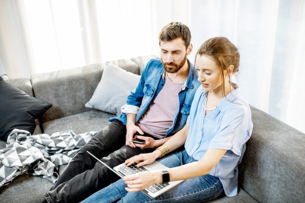 Couple sitting with a laptop at home