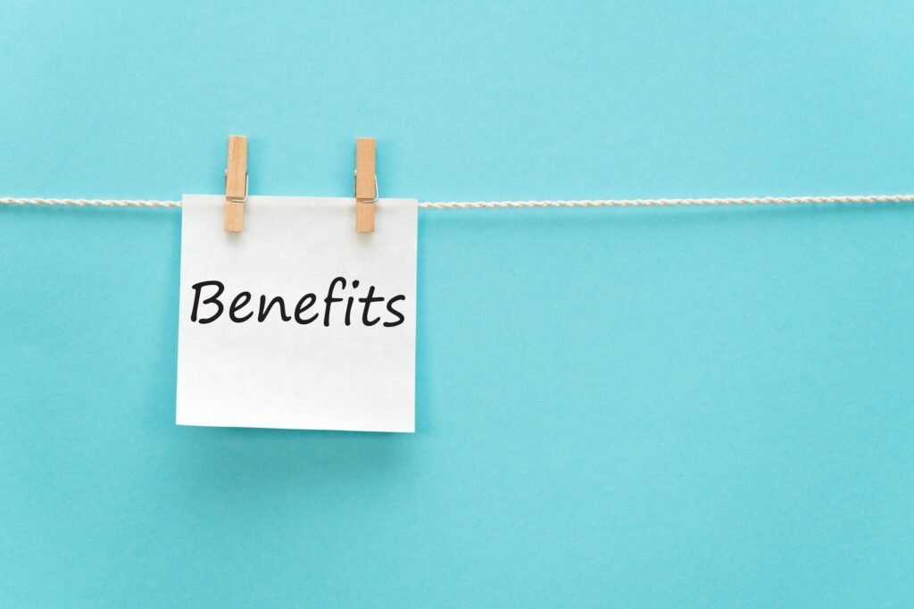 A sticker reading "benefits" hanging from a clothespin on a rope