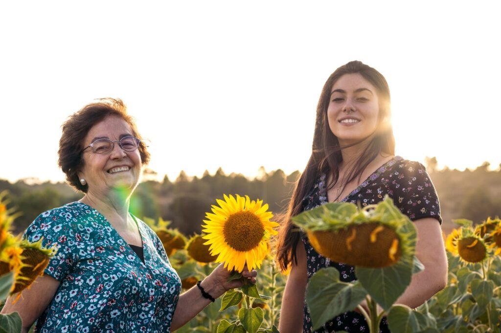 Grandmother and granddaughter in a field of sunflowers